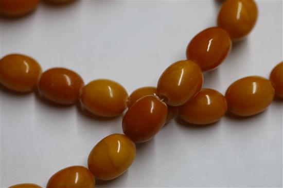 A single strand graduated oval amber bead necklace, gross weight 104 grams, 86cm.